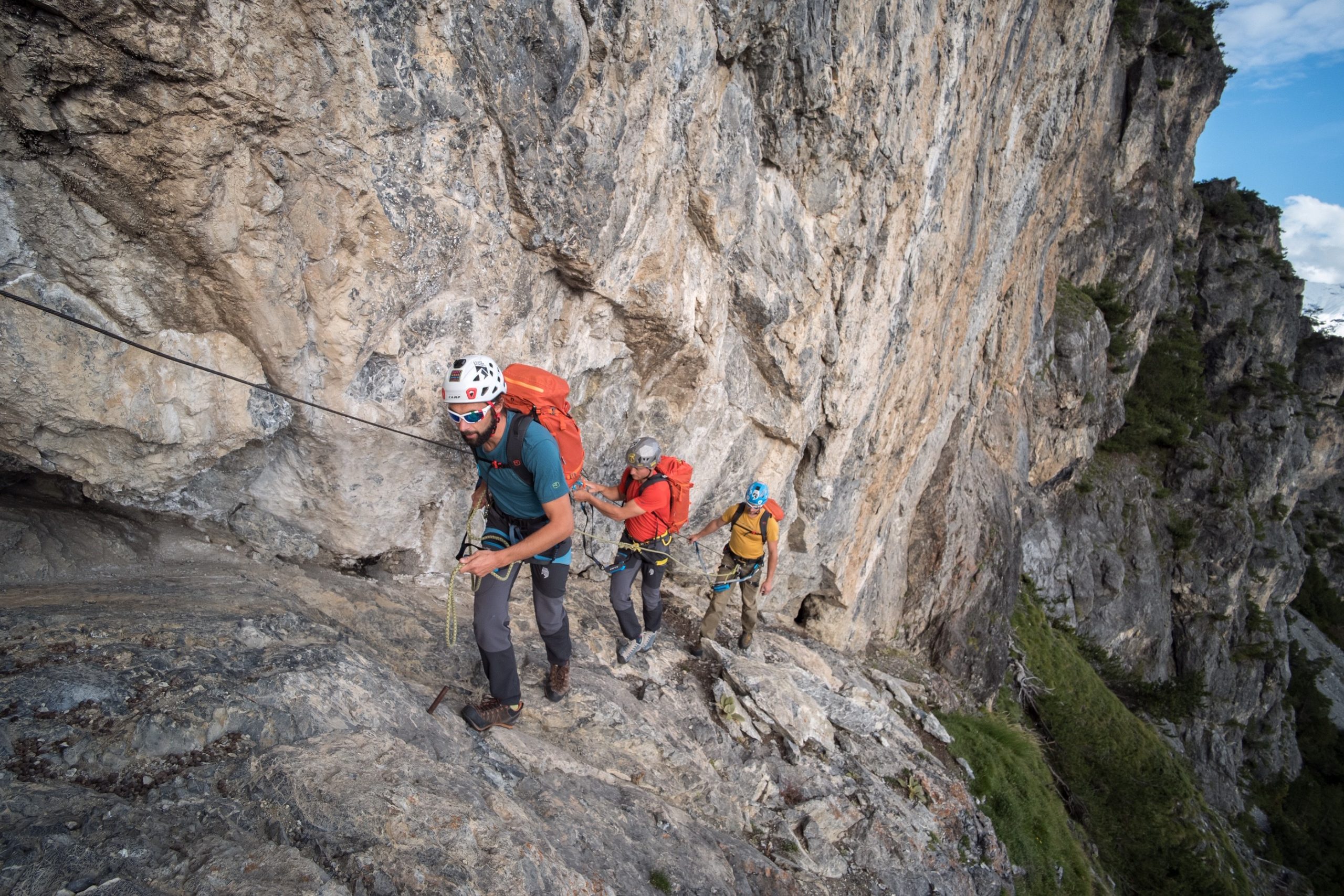 Gruppo di Alpinisti mentre scalano una montagna a Bormio. Indossano il caschetto e l'attrezzattura adeguata.
