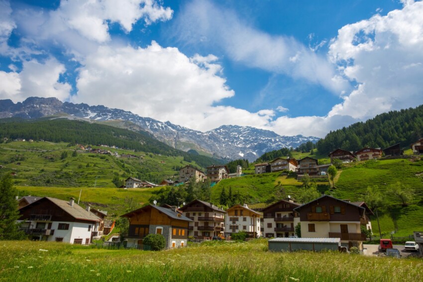 Scenario del paese di Santa Caterina di Valfurva: casette totalmente immerse nel verde della natura, tra le montagne.
